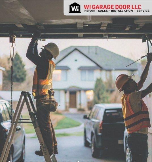 Two workers in orange safety vests installing a garage door at a home construction site