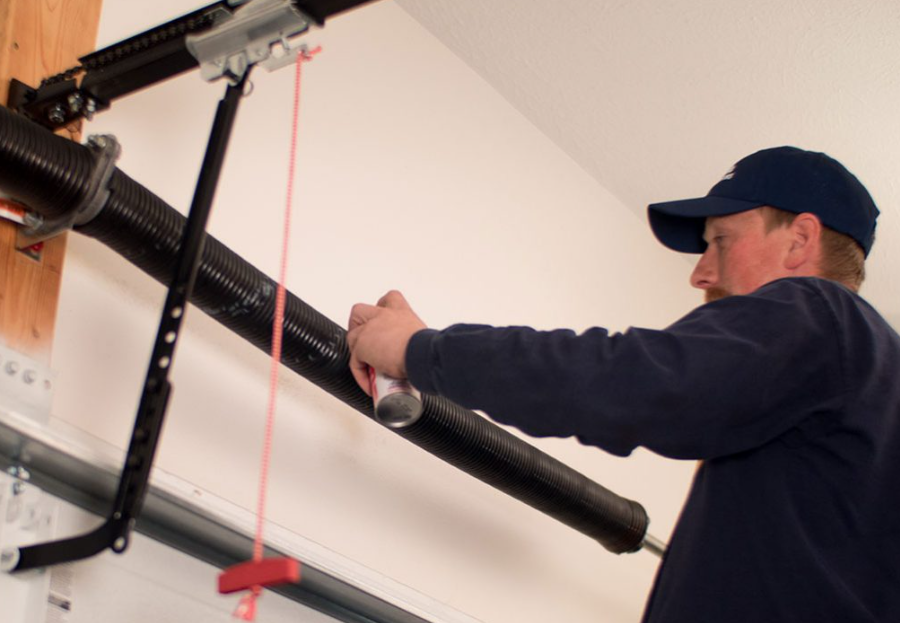 Technician adjusting a garage door opener rail with a red string guide