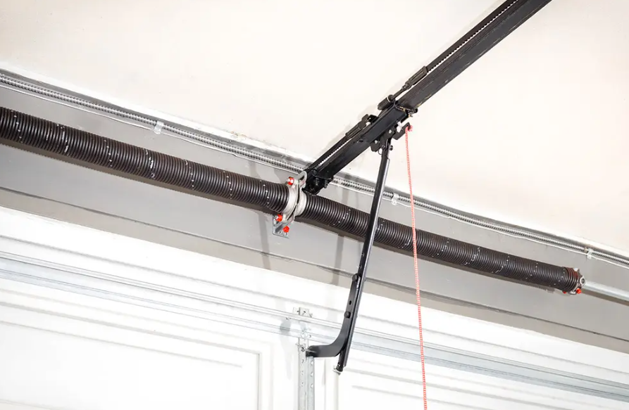Garage door opener rail and hanging cord on a ceiling near a white garage door