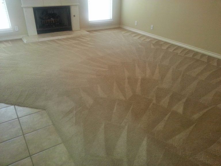 A yellow commercial floor scrubber machine deep cleans a carpeted surface, leaving a trail of white cleaning foam.
