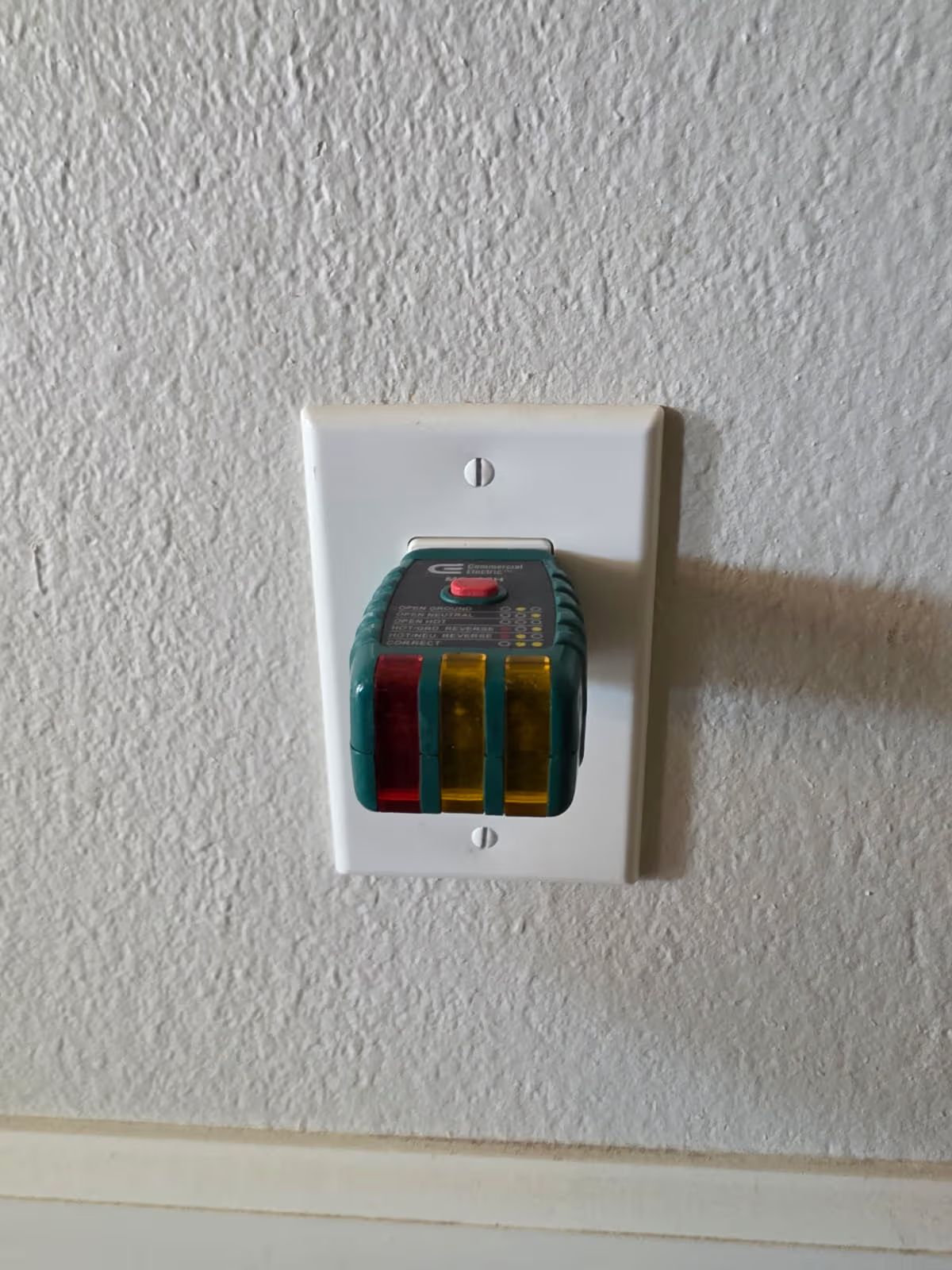Open electrical panel in stucco wall with exposed wiring above and utility meter below.