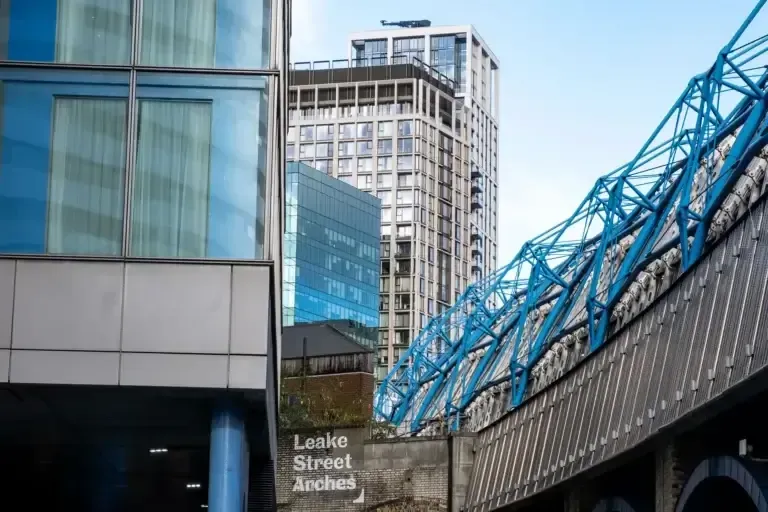 Modern city buildings with blue bridge structure; London, UK.