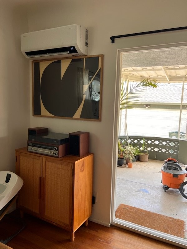 A room with a sliding glass door and a picture on the wall.