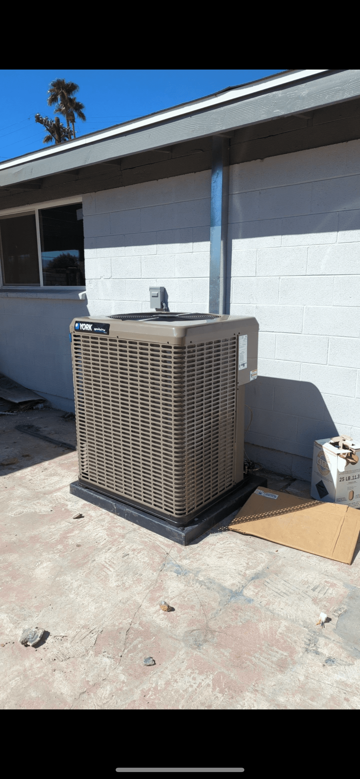 A large air conditioner is sitting on the side of a house.