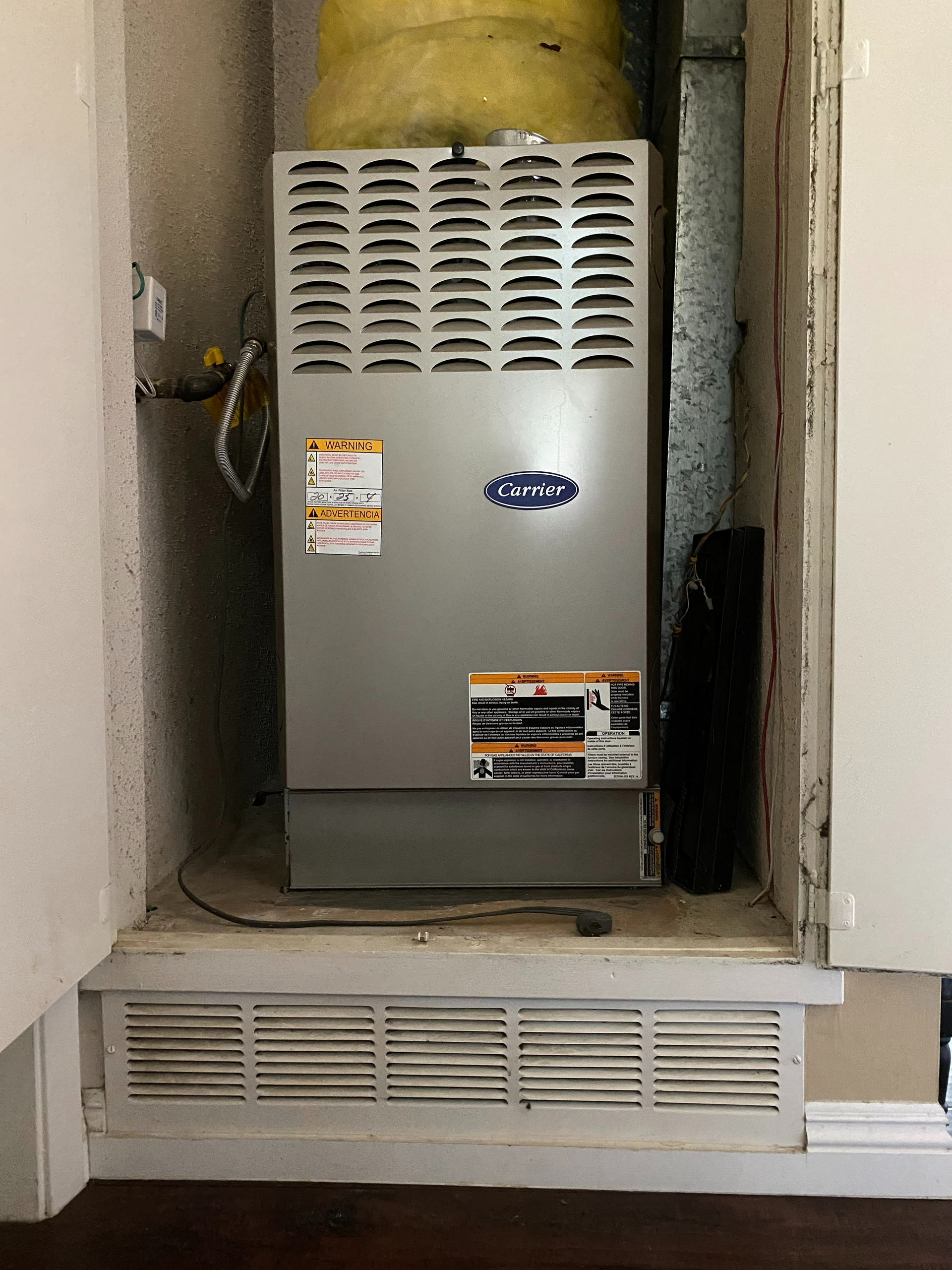 An air conditioner is sitting in a corner of a room.