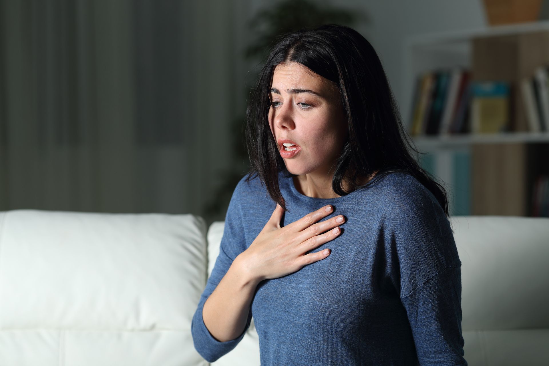 Woman experiencing respiratory discomfort indoors due to poor indoor air quality in Southern, CA.