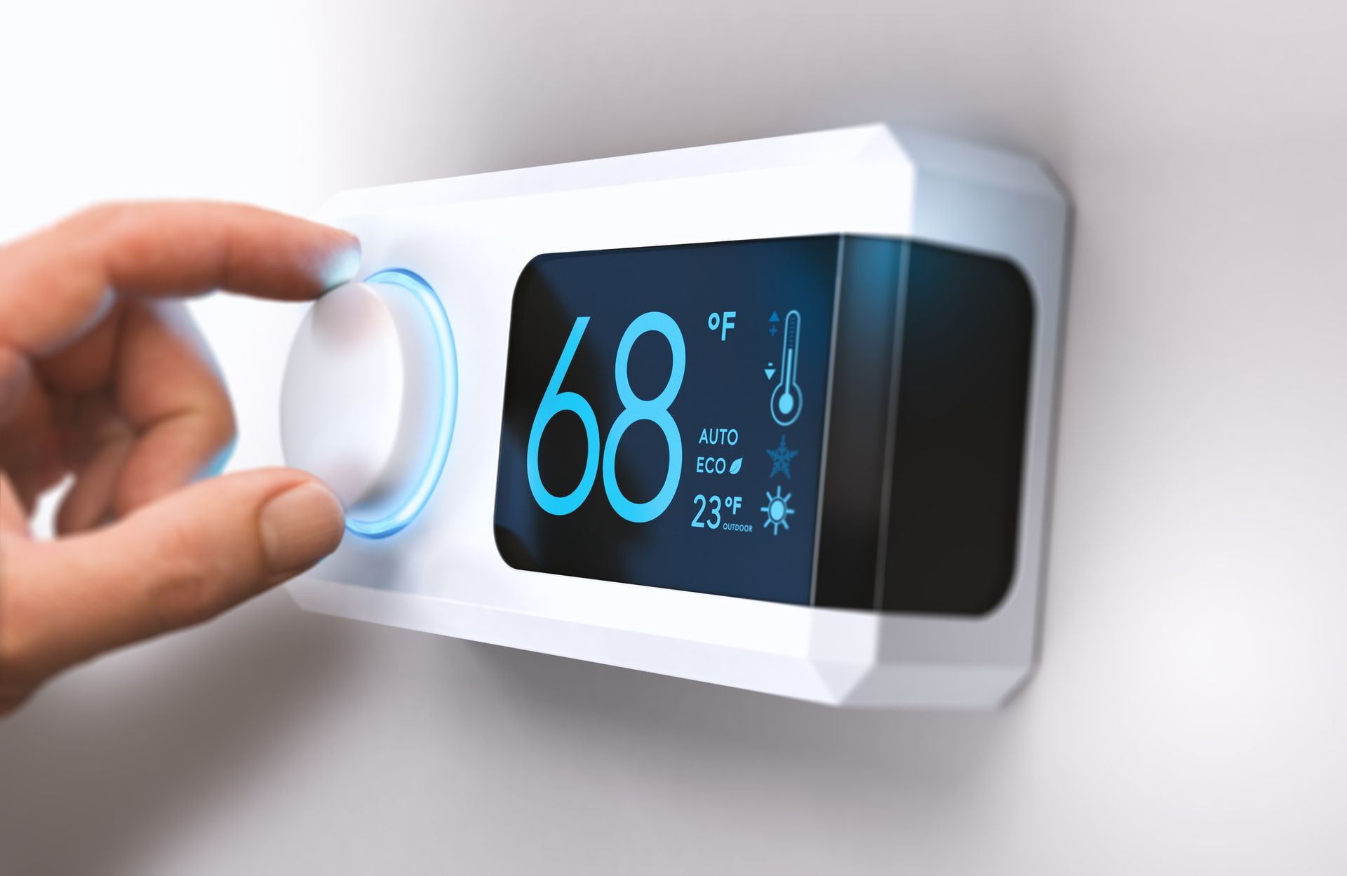 Homeowner adjusting a thermostat to lower winter energy bills for heating in Southern California.