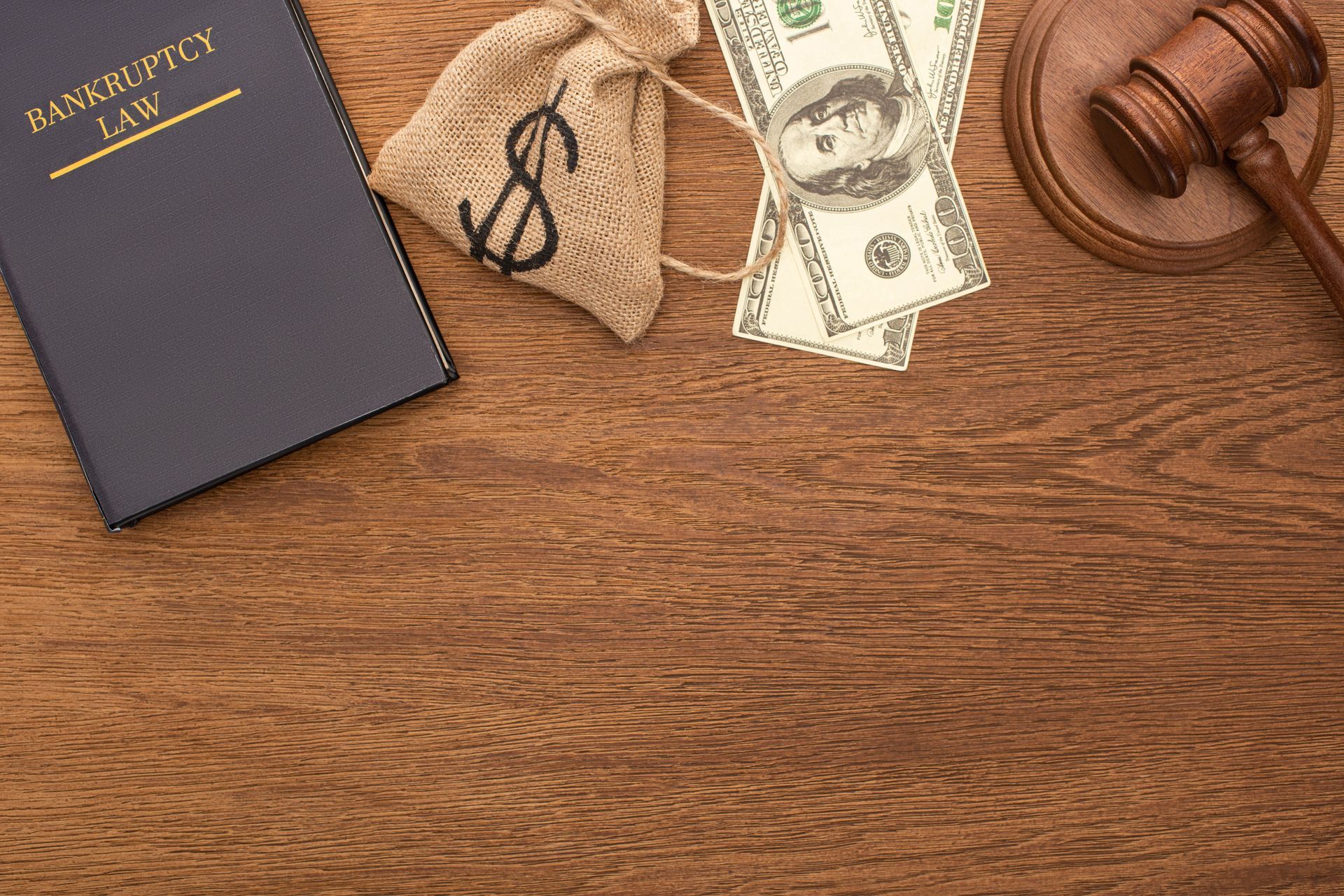 Wooden desk with an estate planning binder, eyeglasses, cash, gavel, and a power of attorney form