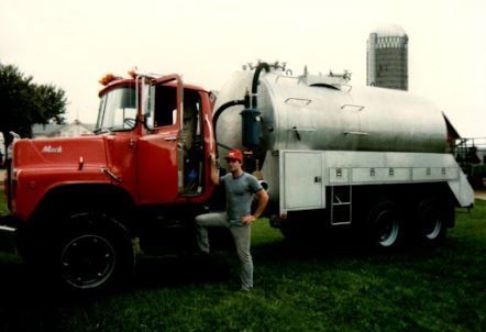 Man Standing Beside the Big Red Truck — Malone, WI — Ziegelbauer Septic Service LLC