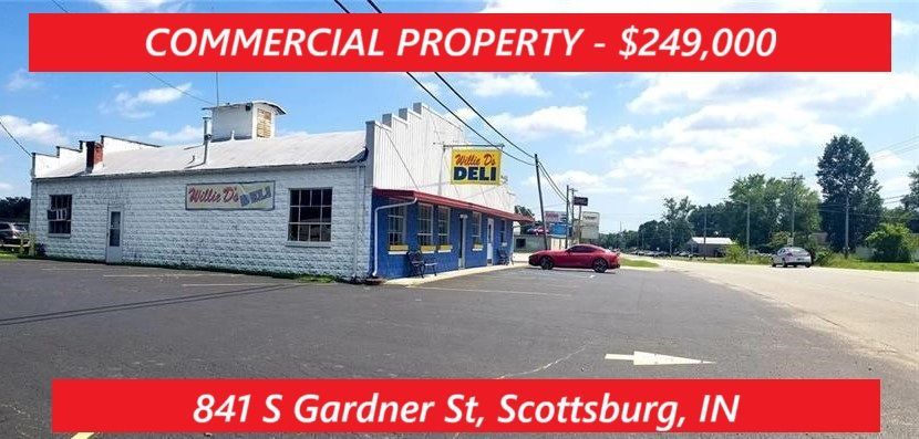 Commercial property for sale, Scottsburg, IN.  Building with a white facade and blue accents, red car in the driveway.