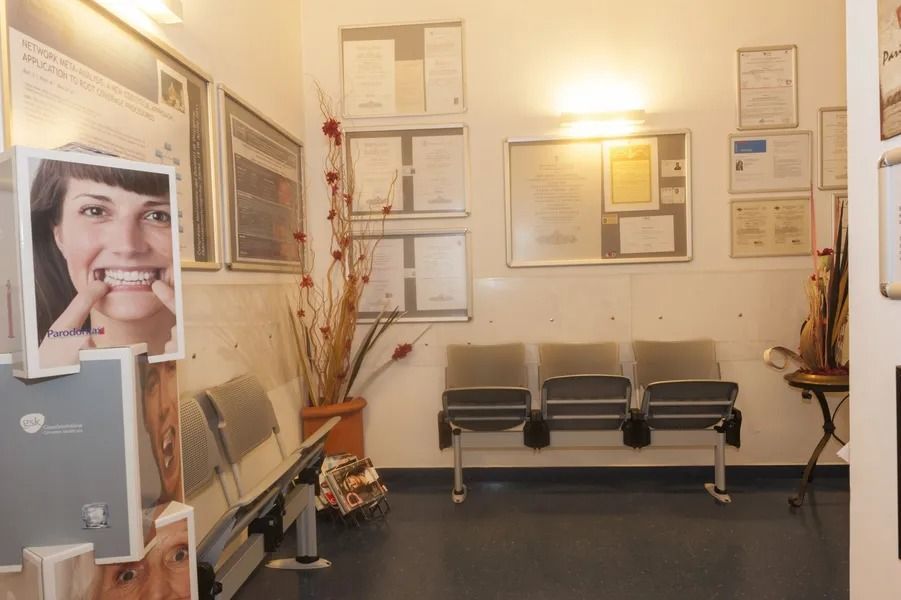 Sala d'attesa: sedie, poster, diplomi alle pareti, fiori in un vaso.