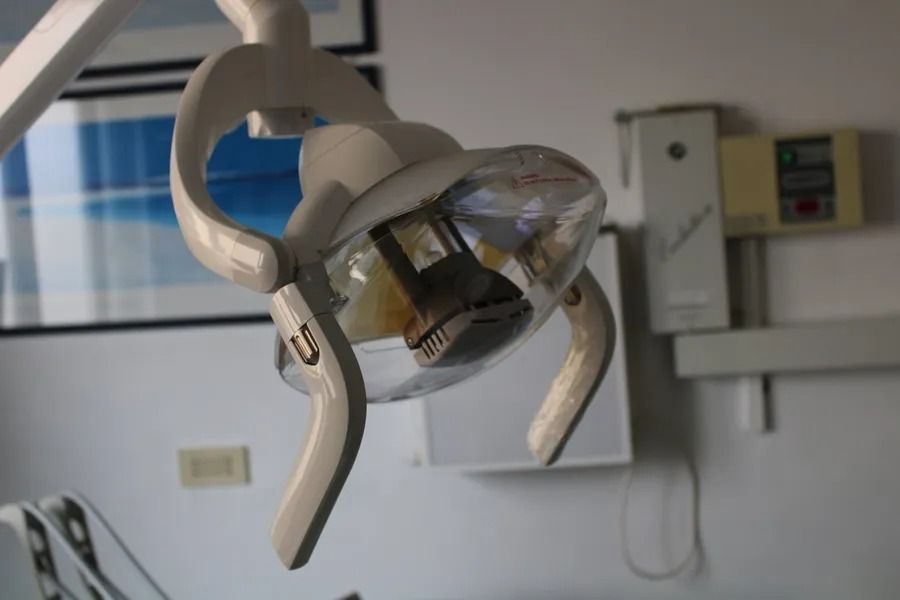Lampada per visita odontoiatrica in uno studio dentistico. Luce bianca curva con copertura trasparente a cupola.