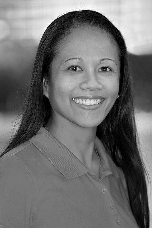 A black and white photo of a smiling woman wearing a polo shirt.