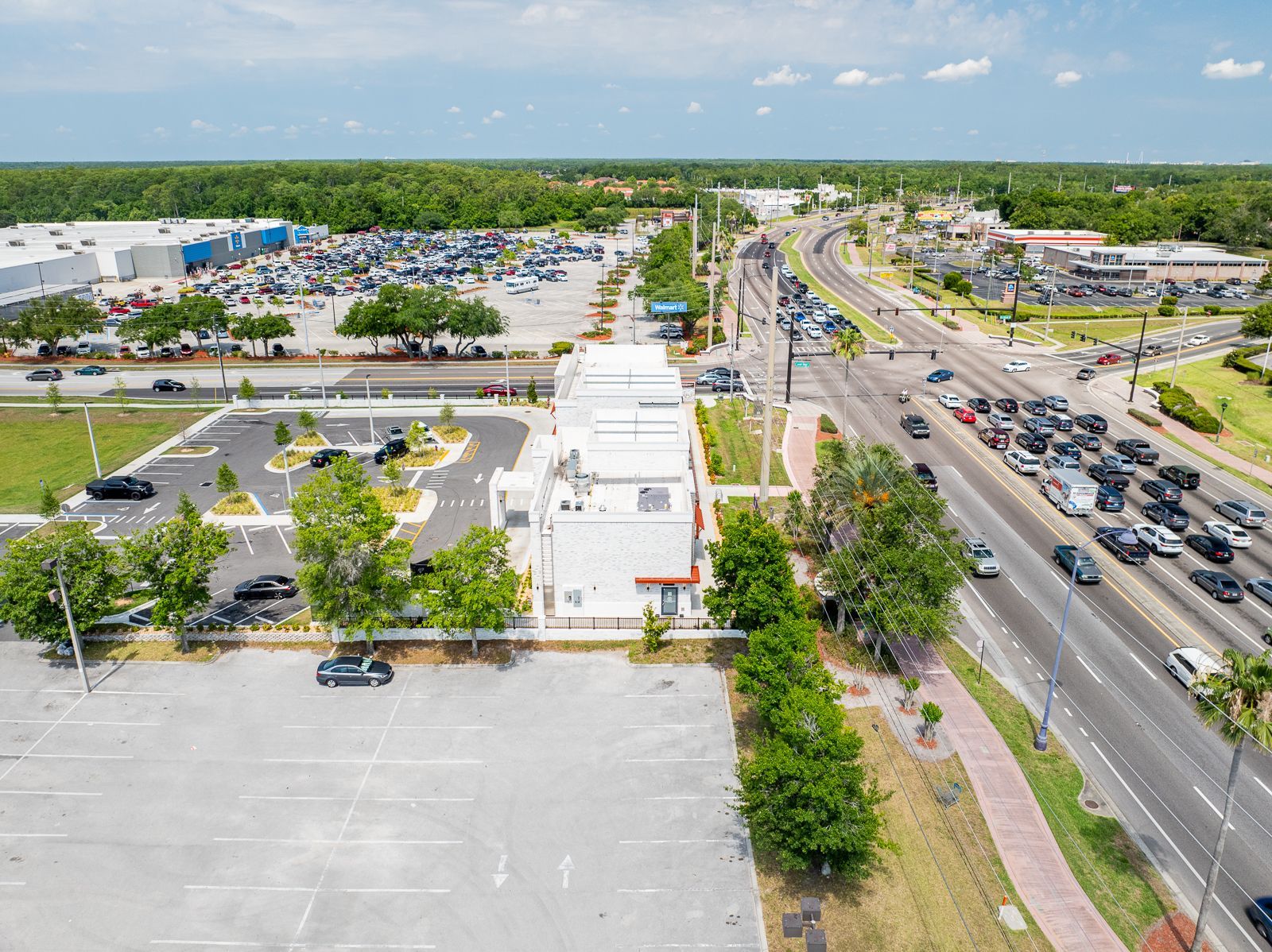An aerial view of a parking lot next to a highway.
