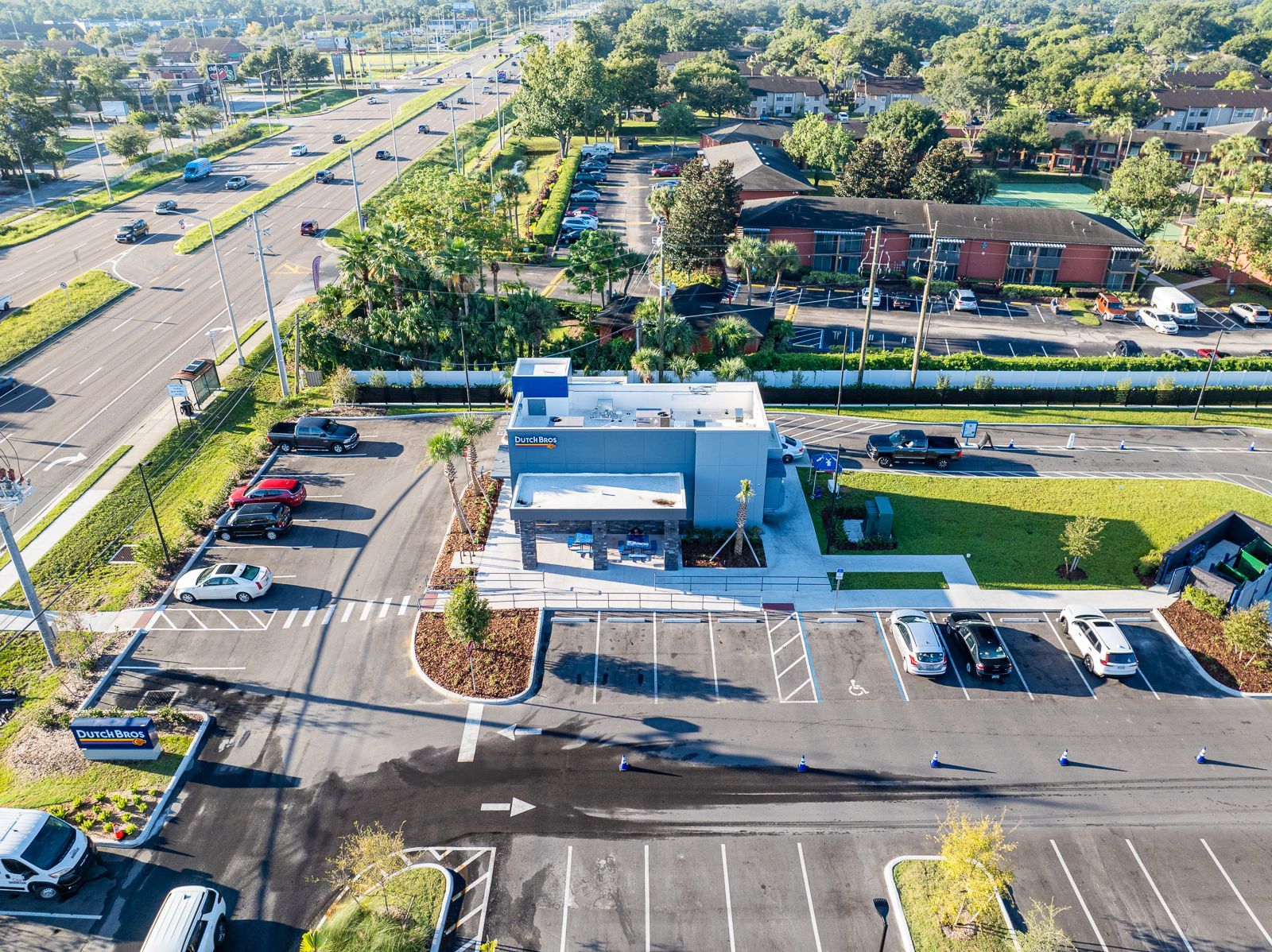 An aerial view of a parking lot with cars parked in front of a building.