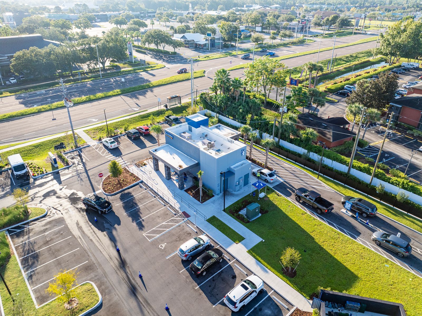 An aerial view of a parking lot with cars parked in front of a building.