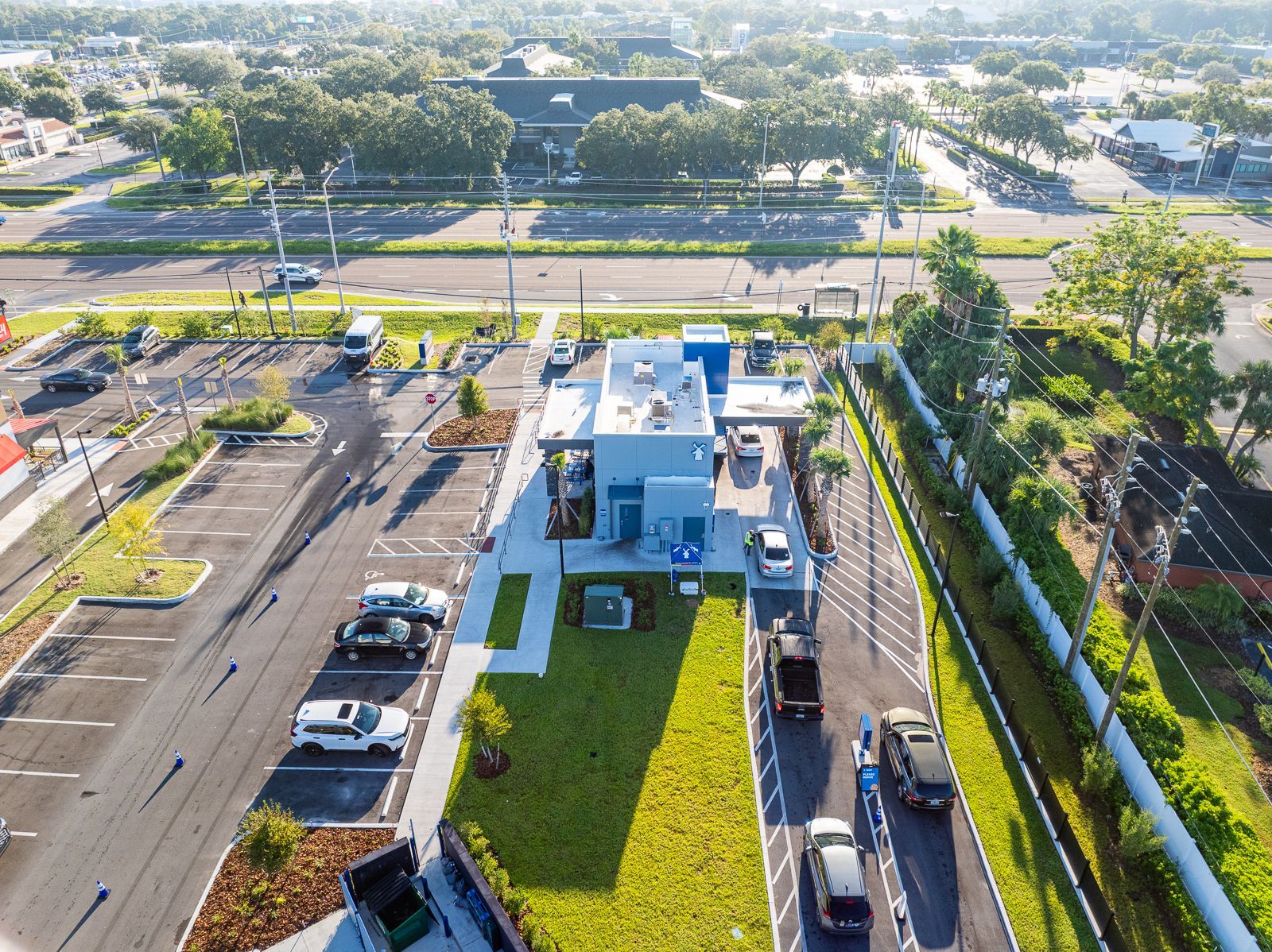 An aerial view of a parking lot with cars parked in front of a building.