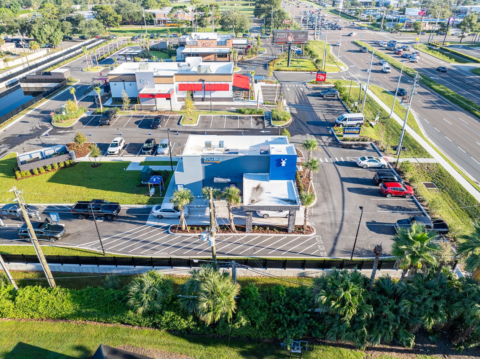 An aerial view of a fast food restaurant with a lot of cars parked in front of it.