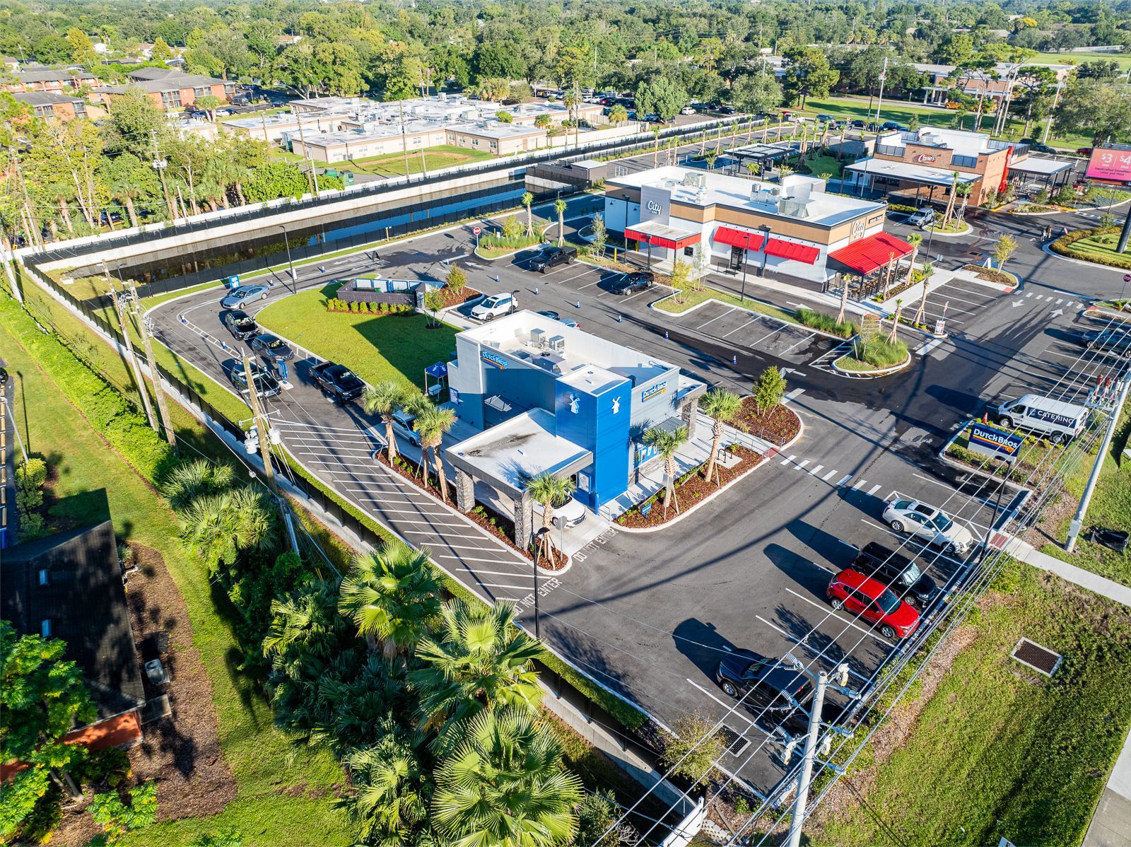 An aerial view of a parking lot with a lot of cars parked in it.