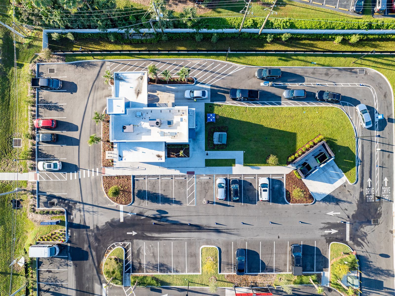 An aerial view of a parking lot with a building in the background.