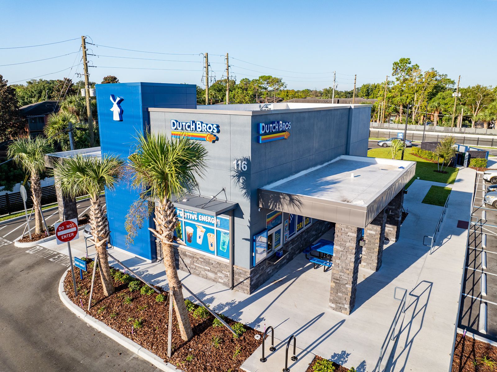 An aerial view of a building with palm trees in front of it