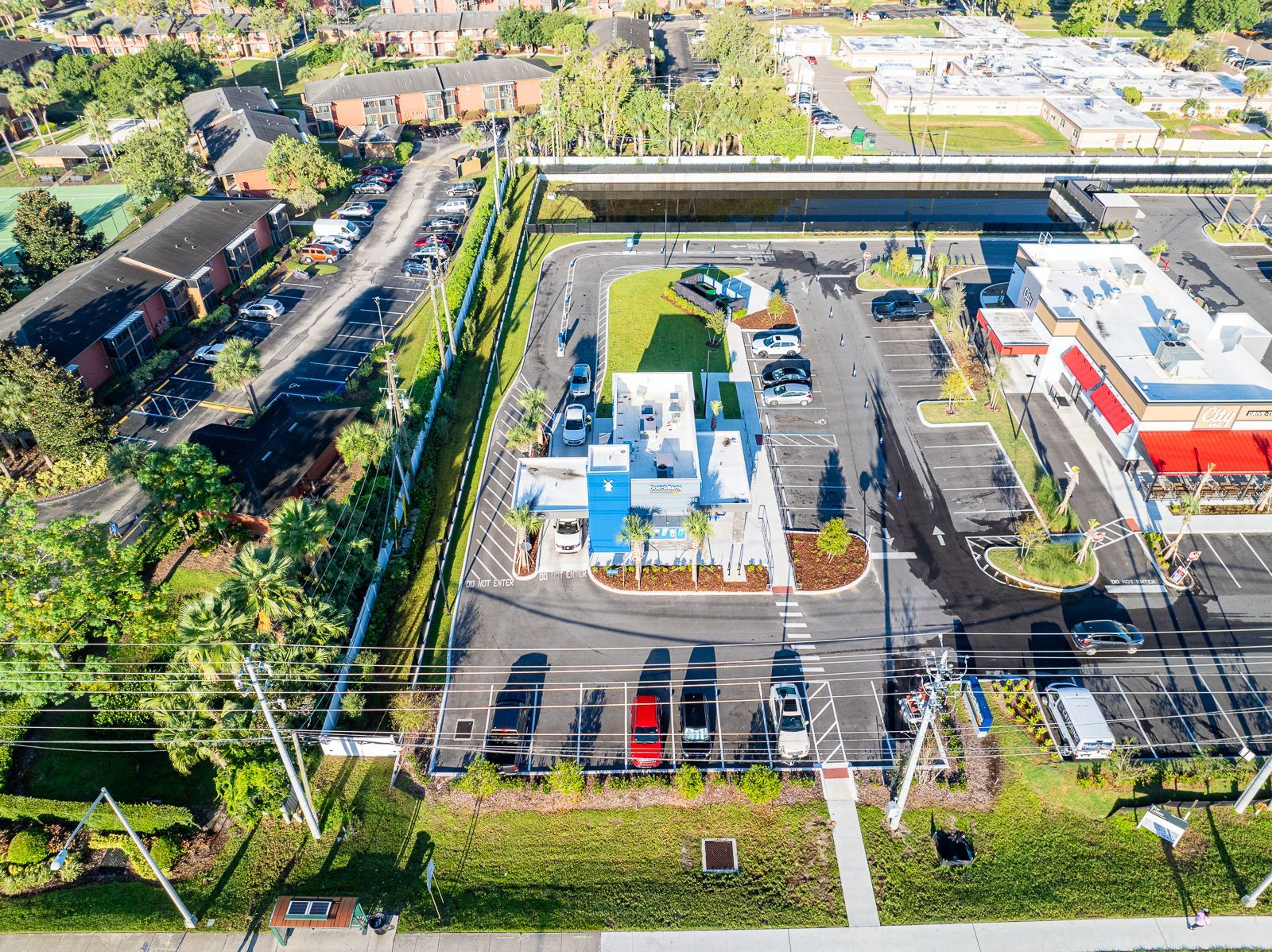 An aerial view of a parking lot surrounded by trees and buildings.