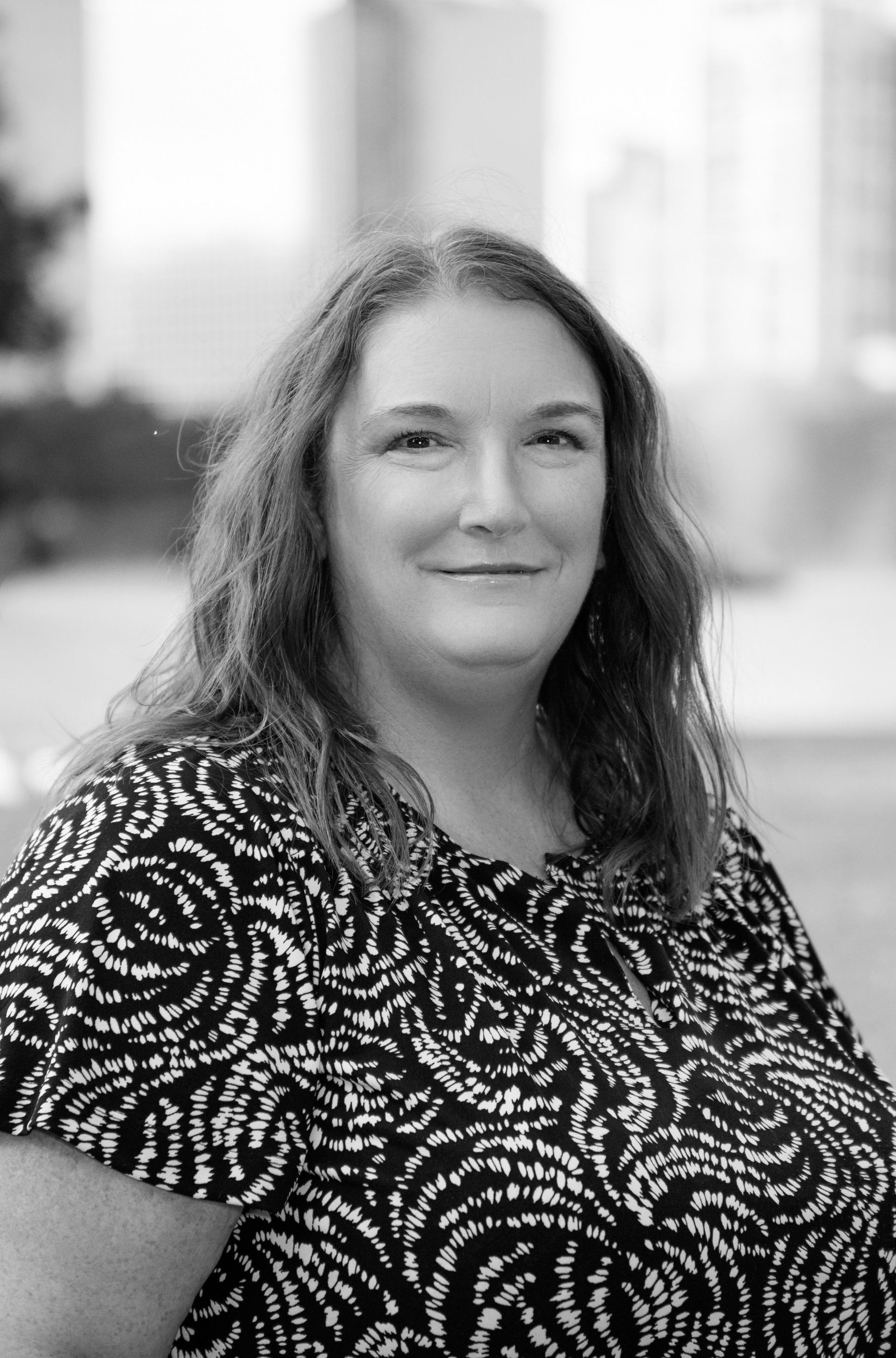 A black and white photo of a woman in a zebra print shirt.