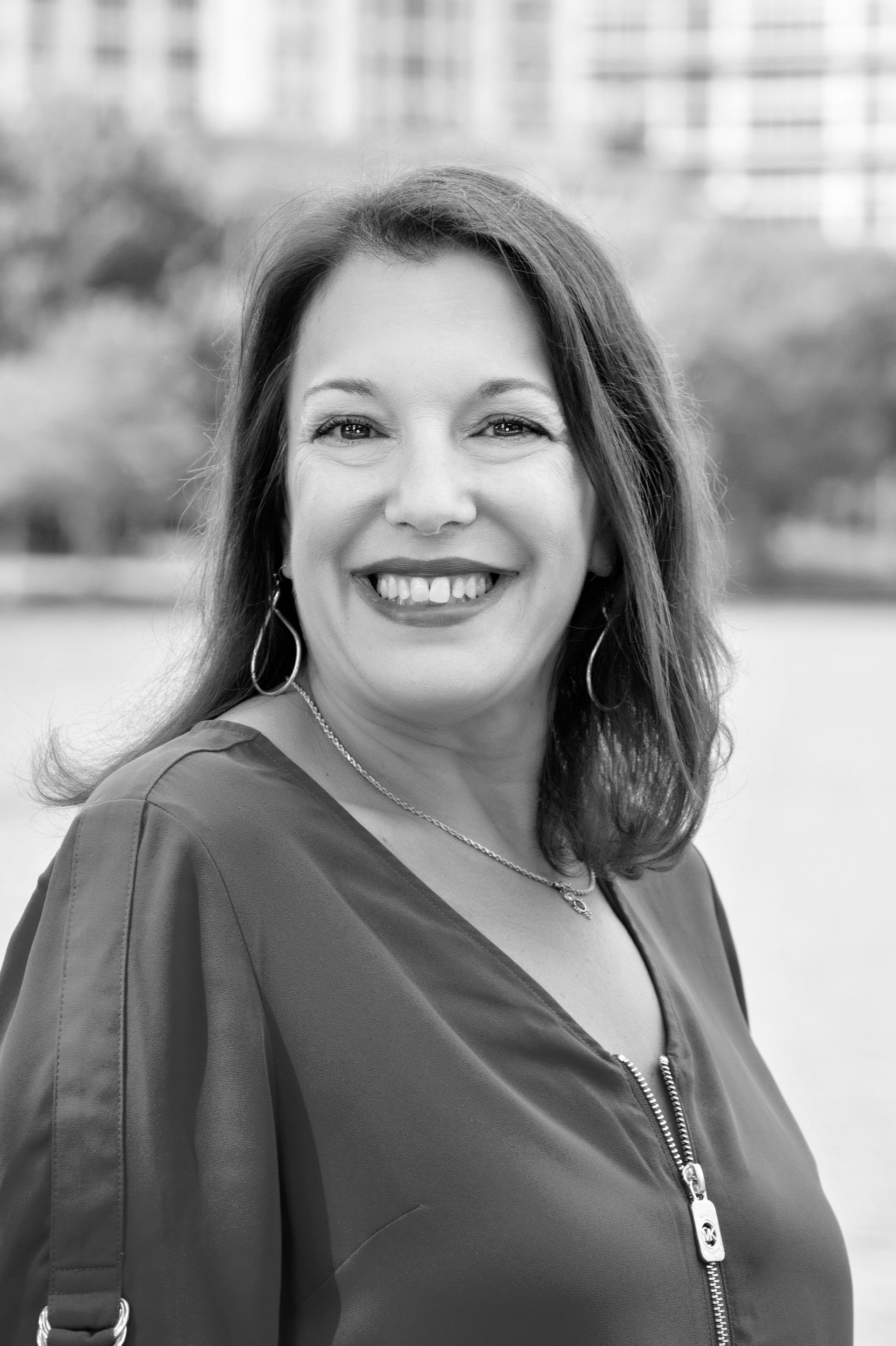 A woman is smiling in a black and white photo.