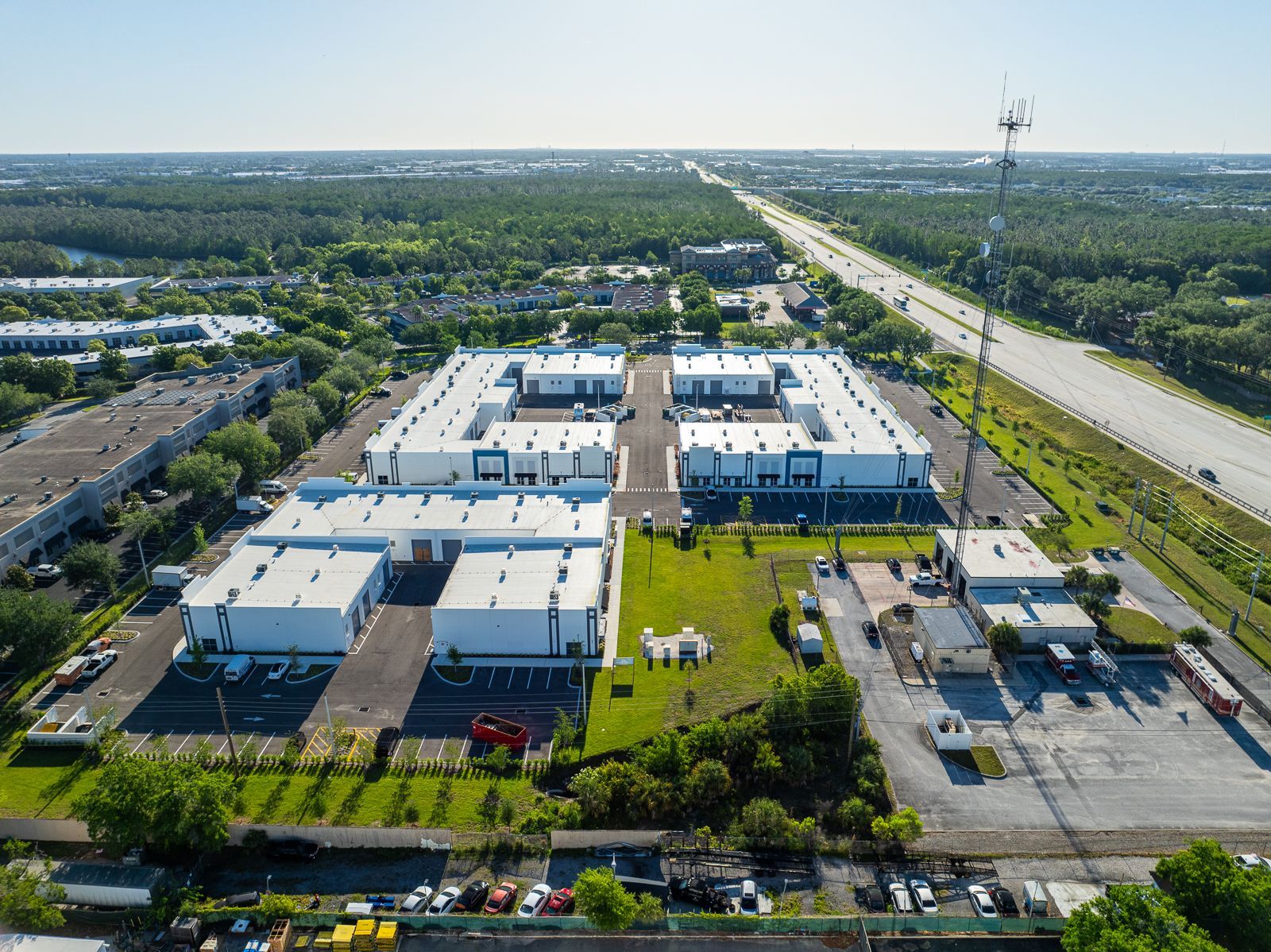 An aerial view of a large industrial area surrounded by trees and a highway.