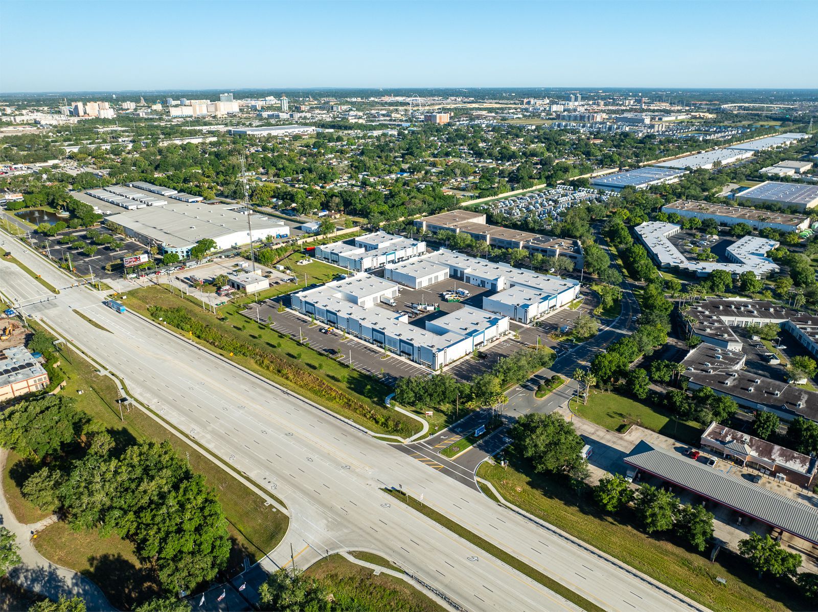 An aerial view of a city with a highway and buildings.