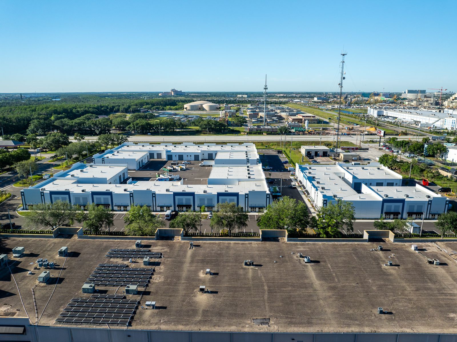 An aerial view of a large building with a lot of cars parked on the roof