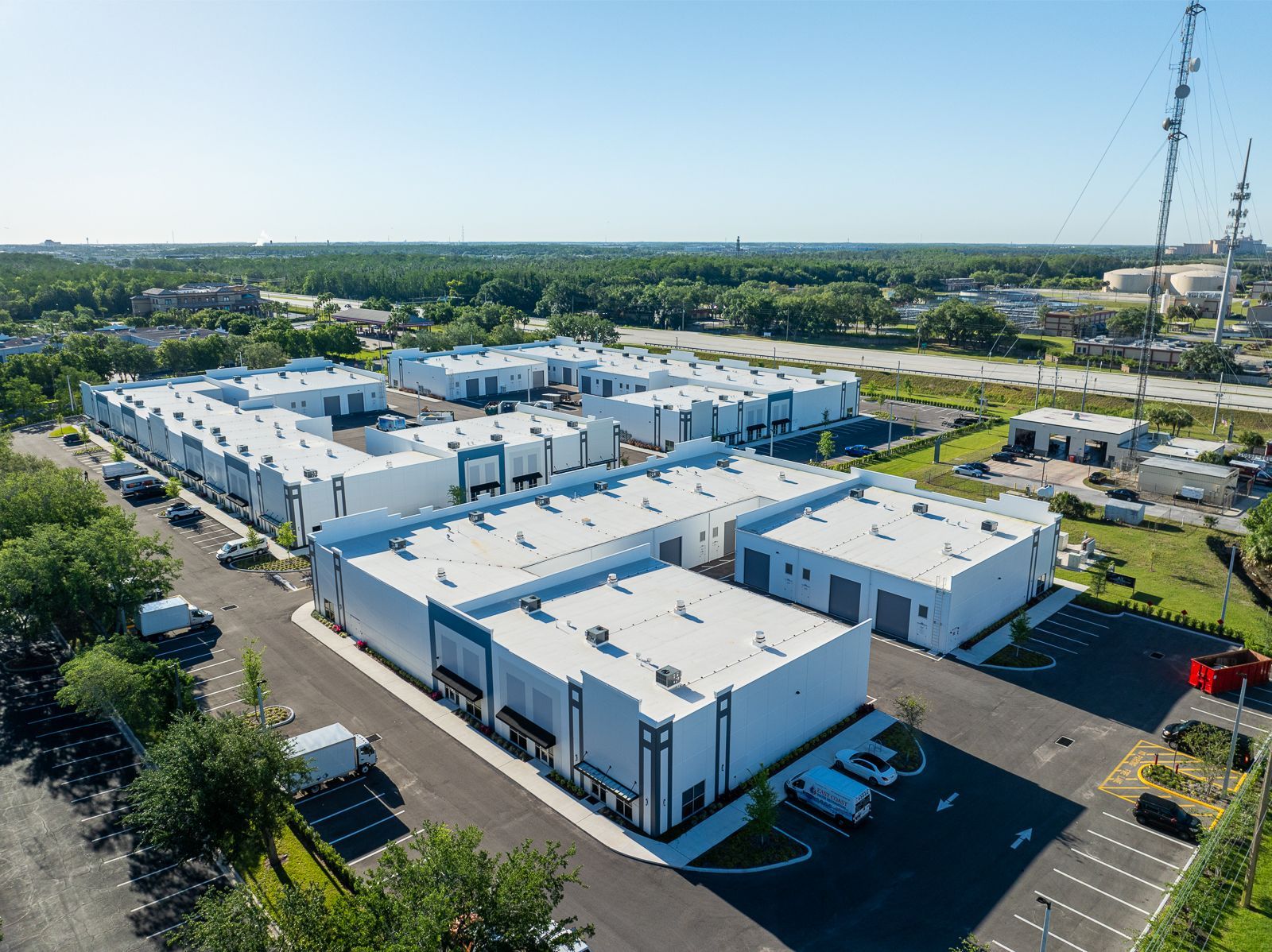 An aerial view of a large white building with a lot of cars parked in front of it.