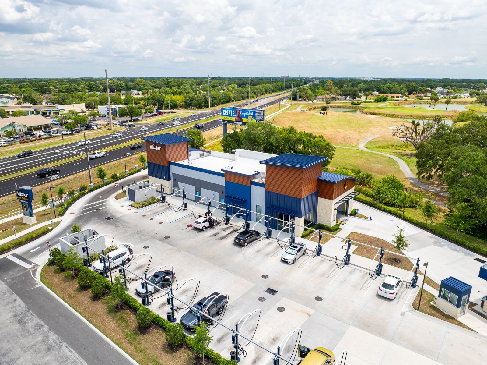 An aerial view of a car wash with cars parked in front of it.