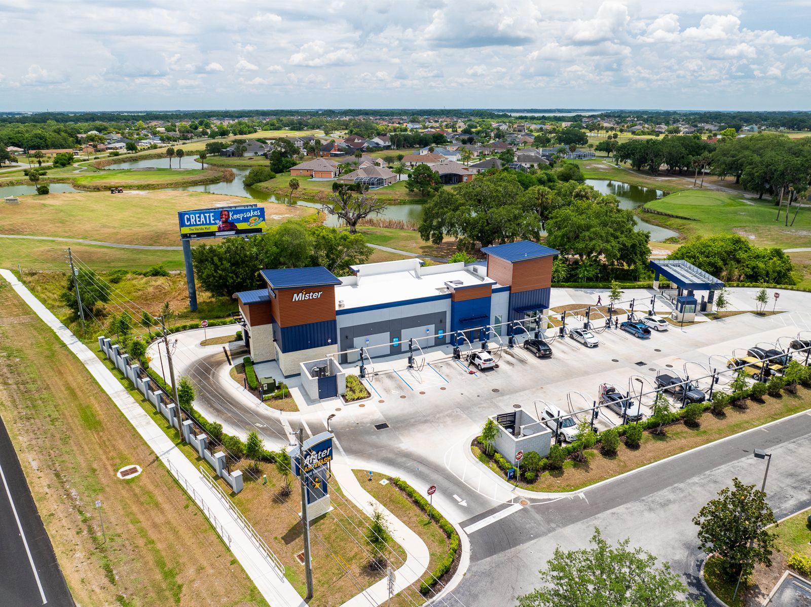 An aerial view of a car wash with a lot of cars parked in front of it.