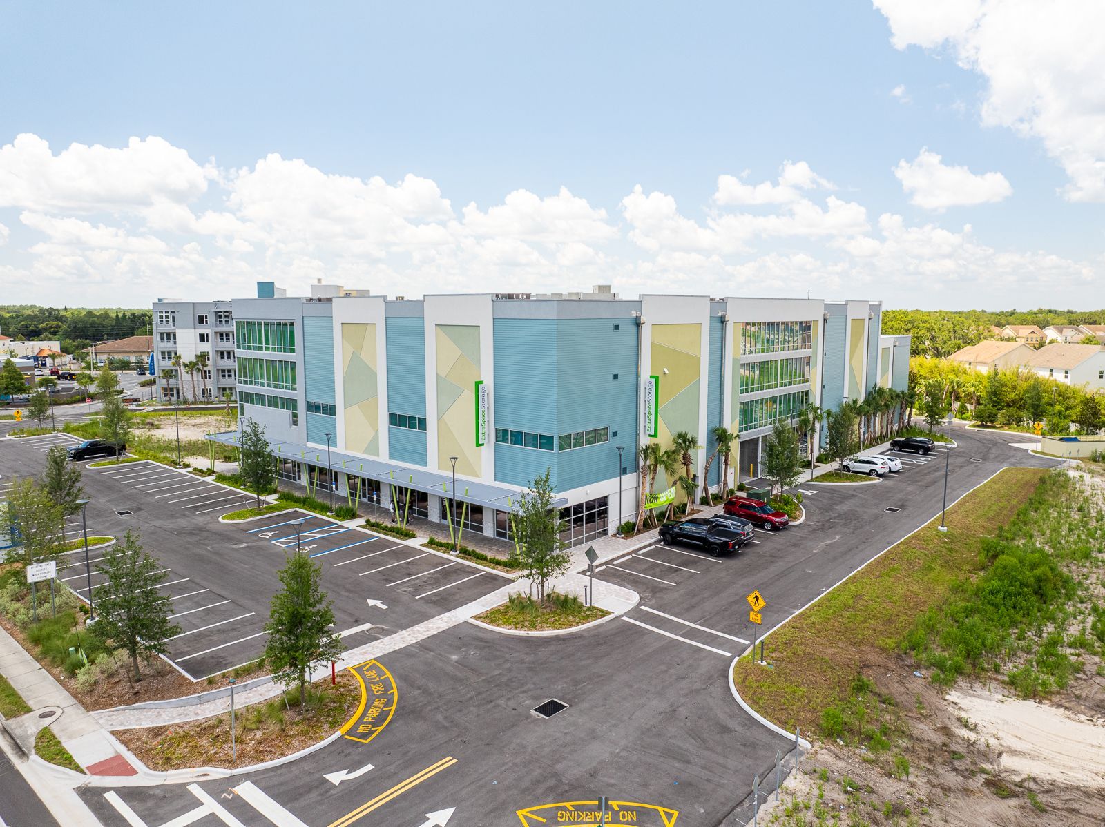 An aerial view of a large building with a parking lot in front of it.