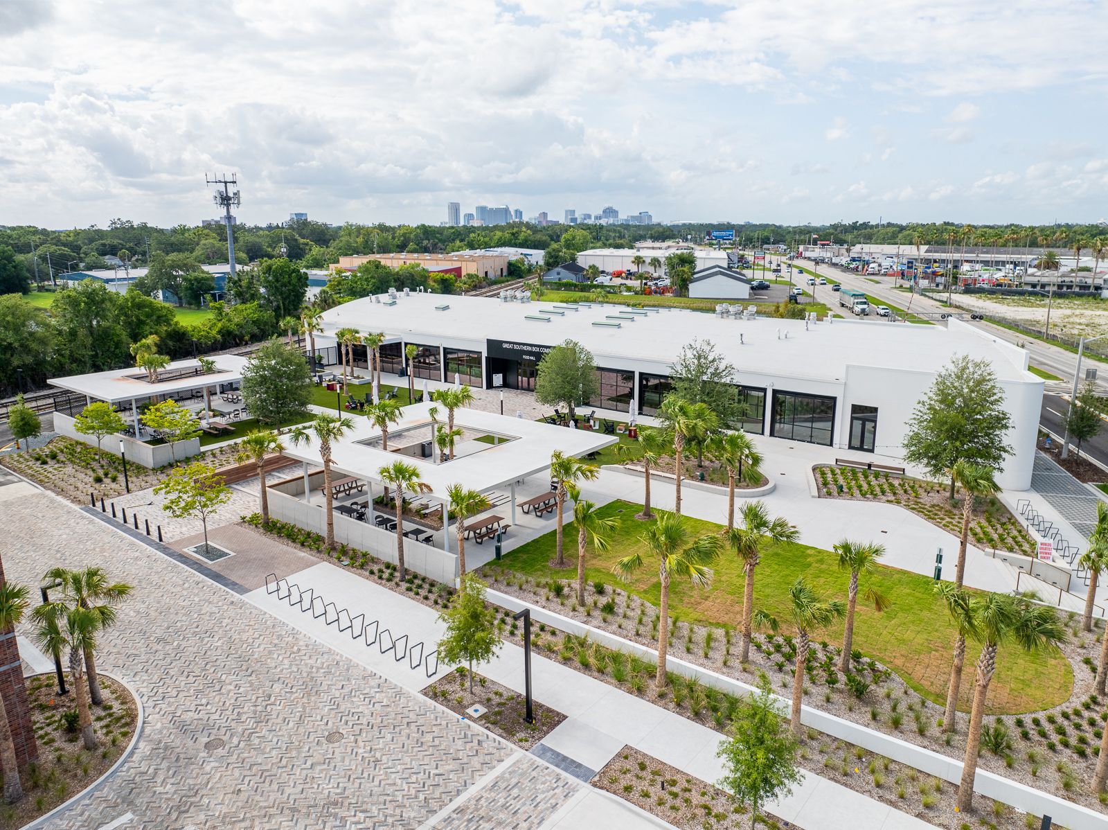 An aerial view of a large white building surrounded by palm trees.
