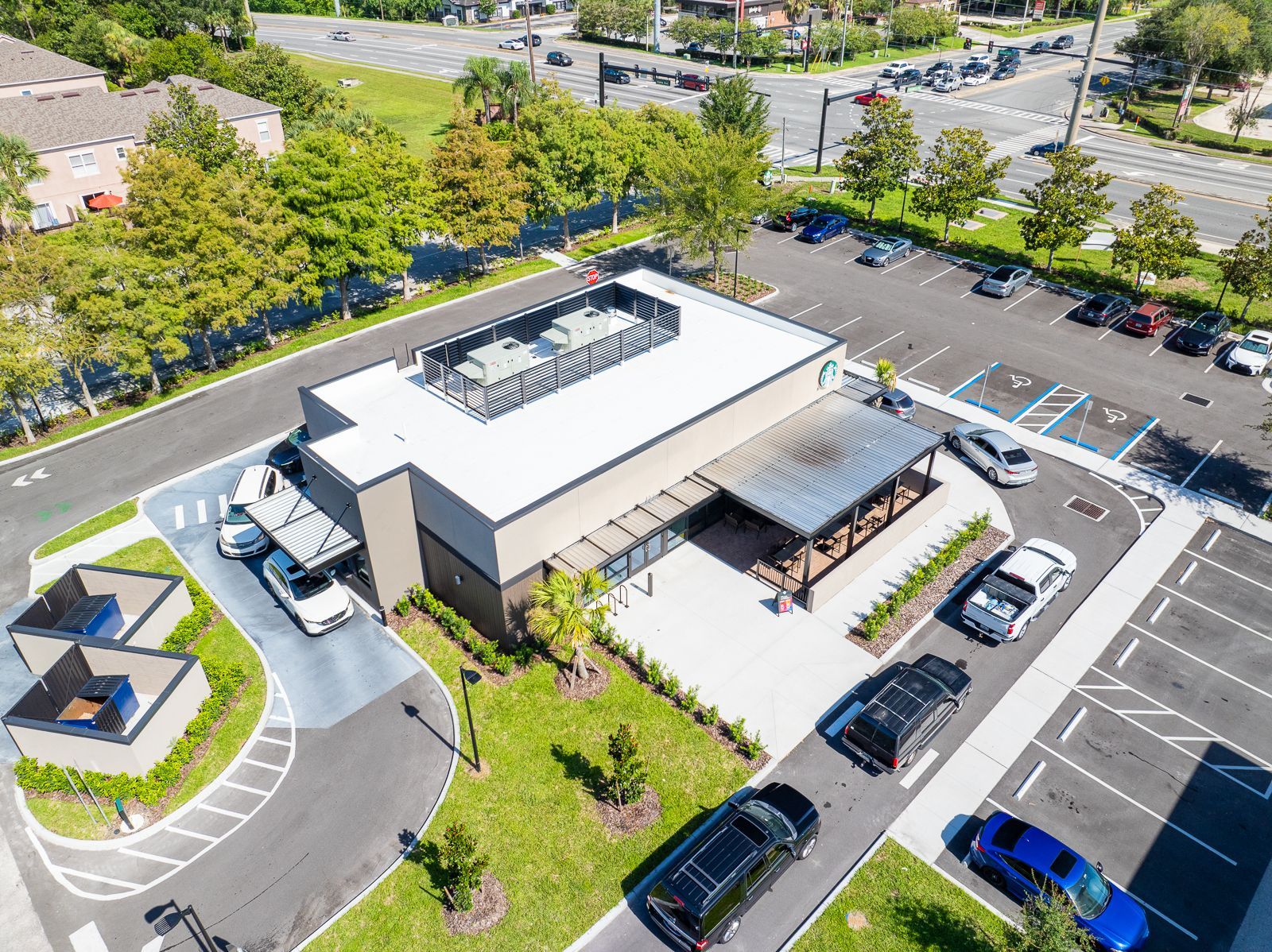 An aerial view of a parking lot with cars parked in front of a building.