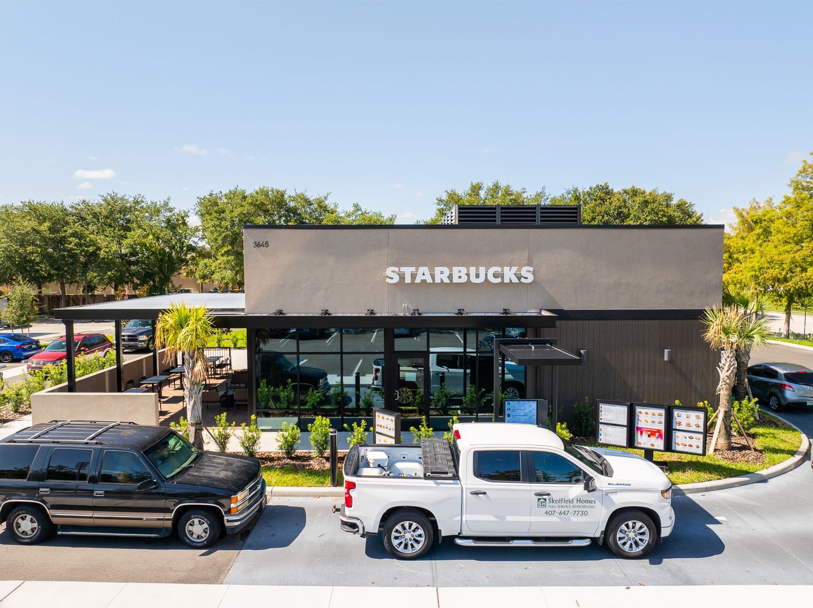 Two trucks are parked in front of a starbucks coffee shop