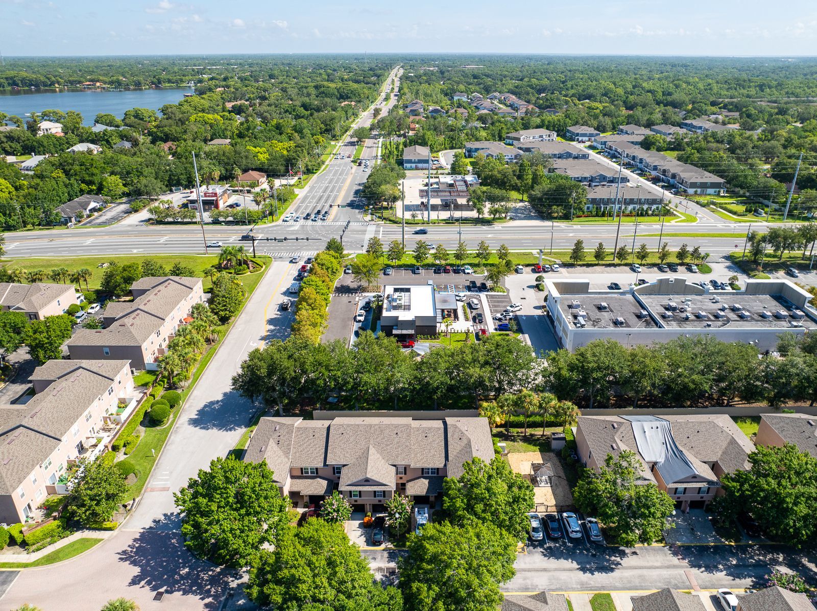 An aerial view of a residential area with a lake in the background.
