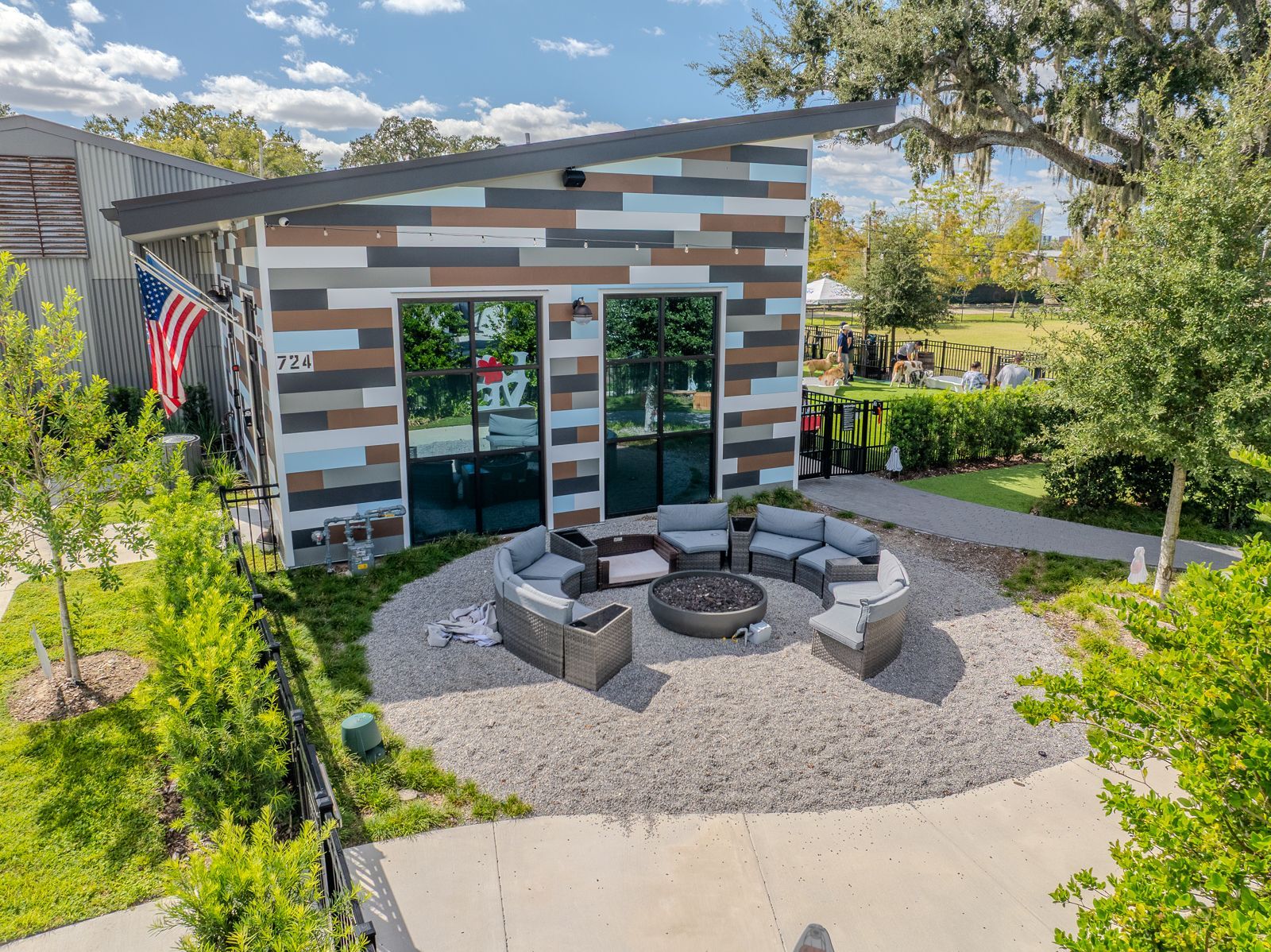Modern building with multi-colored siding, glass doors, and a fire pit seating area.