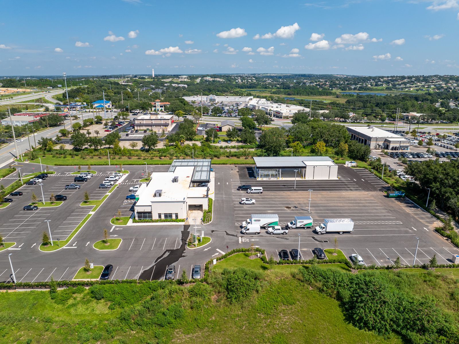 An aerial view of a parking lot with a lot of cars parked in it.