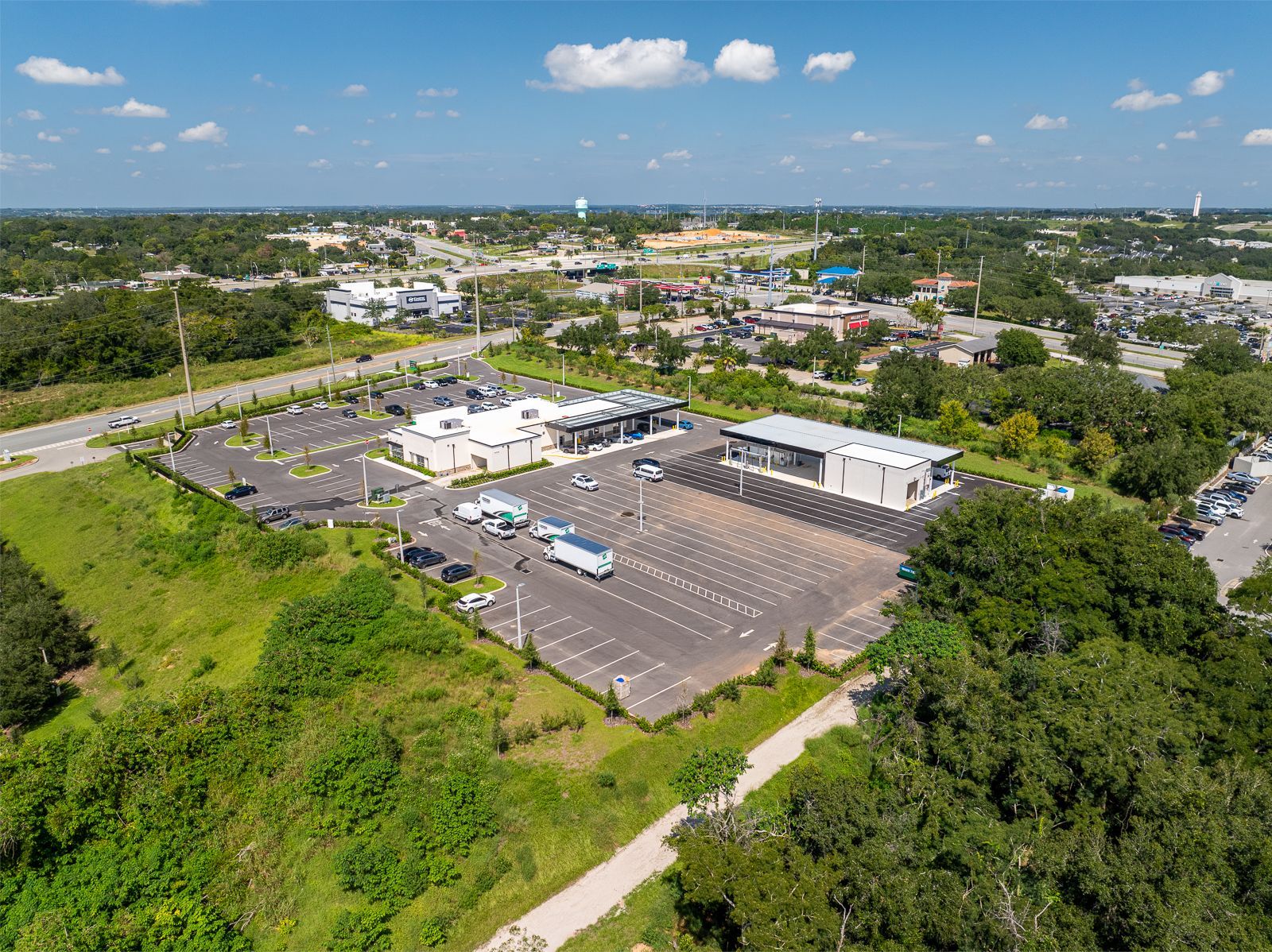 An aerial view of a parking lot surrounded by trees and buildings.
