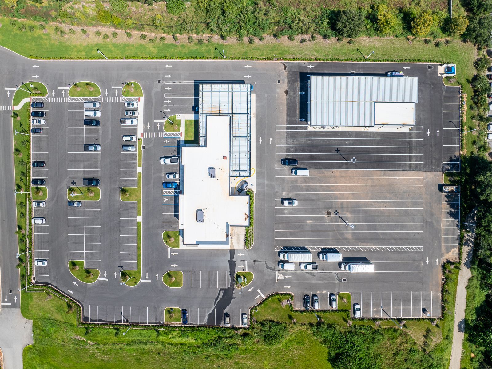 An aerial view of a parking lot with a building in the background