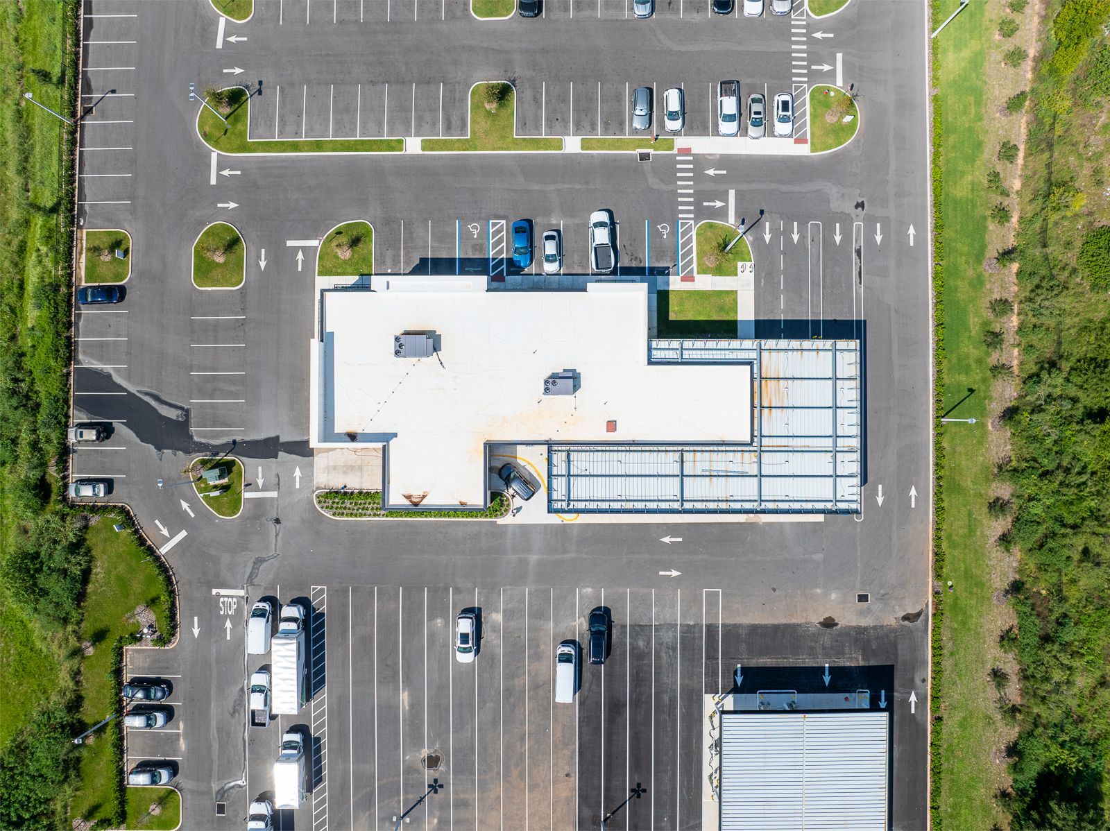 An aerial view of a parking lot with a building in the background