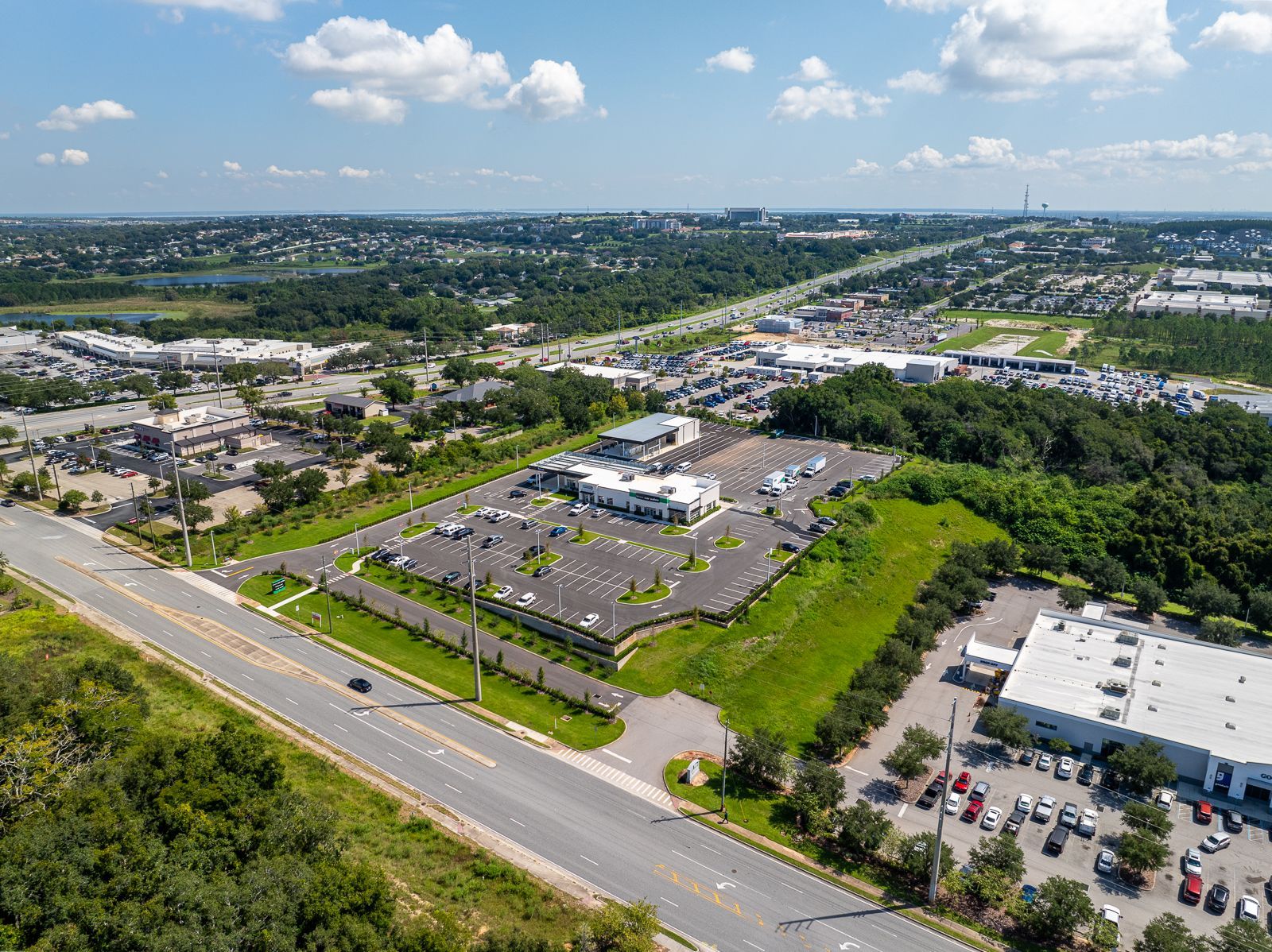 An aerial view of a large parking lot next to a highway.