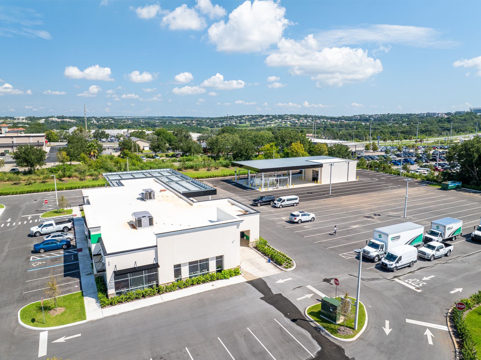 An aerial view of a parking lot with a building in the background.