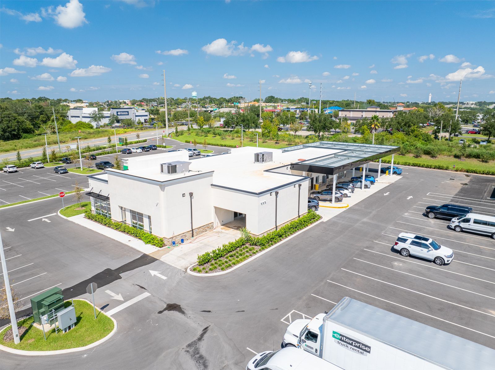 An aerial view of a parking lot with cars parked in front of a building.