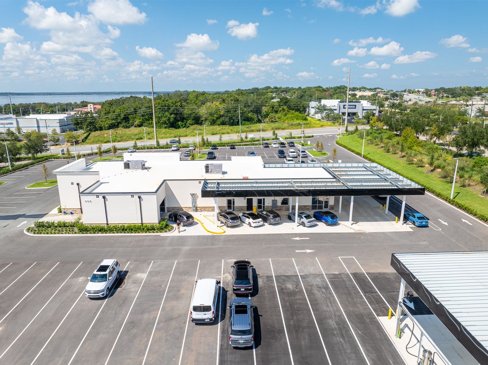 An aerial view of a parking lot with cars parked in front of a building.