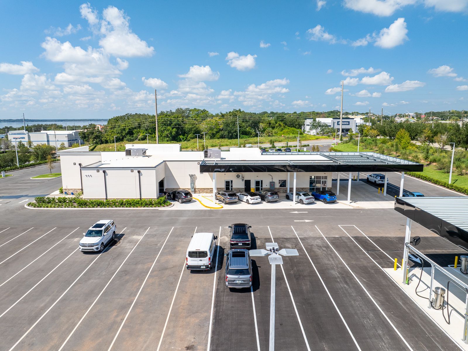 An aerial view of a parking lot with cars parked in front of a building.
