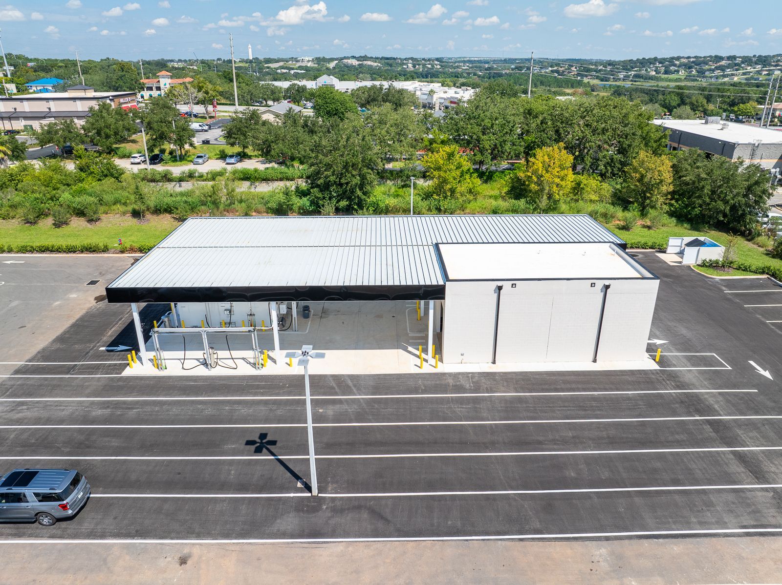 An aerial view of a parking lot with a building in the background